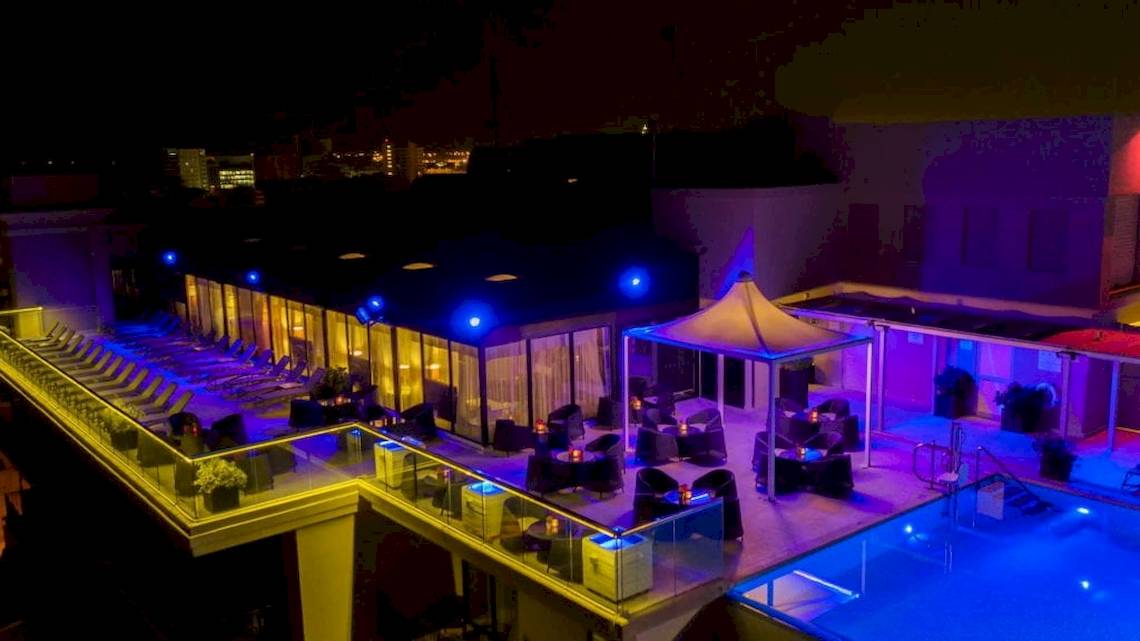 Nachtansicht der Dachterrasse des AX The Palace Hotels mit blauen Beleuchtung und Swimmingpool