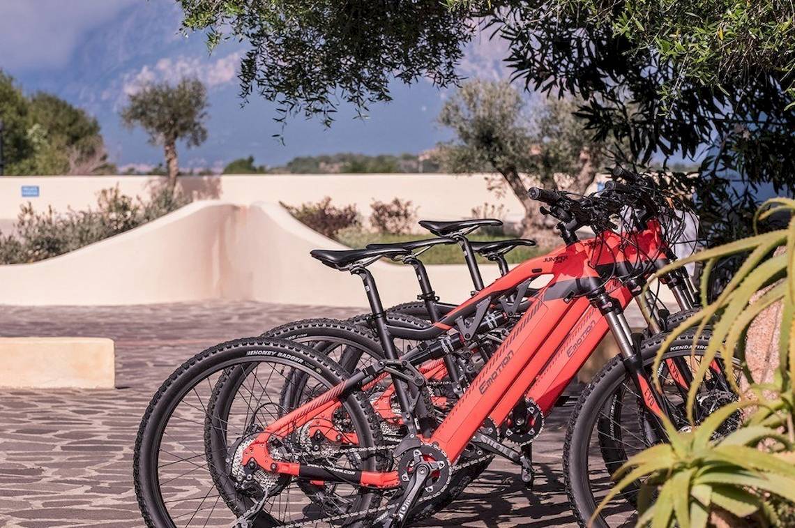 Rote Mountainbikes des Hotel Ollastu Resort unter einem Baum geparkt