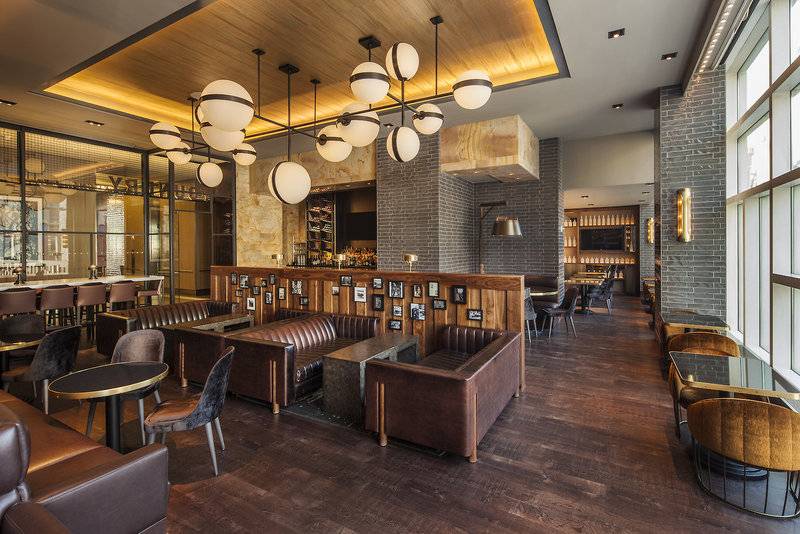 Lobby-Lounge des The Westin New York at Times Square mit braunen Ledersofas und Holzboden.