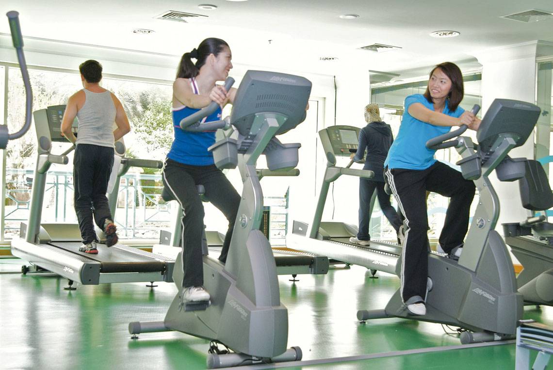 Fitnesscenter im Al Raha Beach Hotel mit Personen auf Trainingsfahrrädern