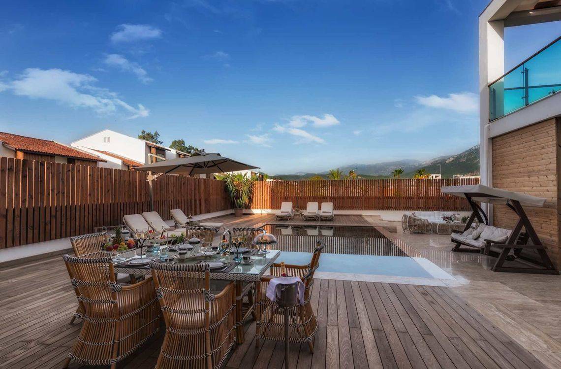 Außenbereich des Rixos Premium Tekirova Hotels mit Swimmingpool und Sitzbereich.