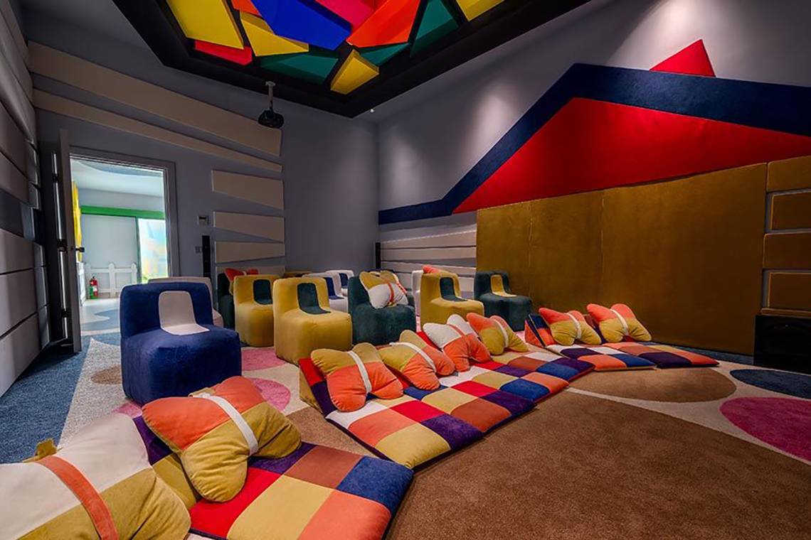 Loungebereich im Rixos Premium Tekirova Hotel mit bunten Sofas und Kissen.