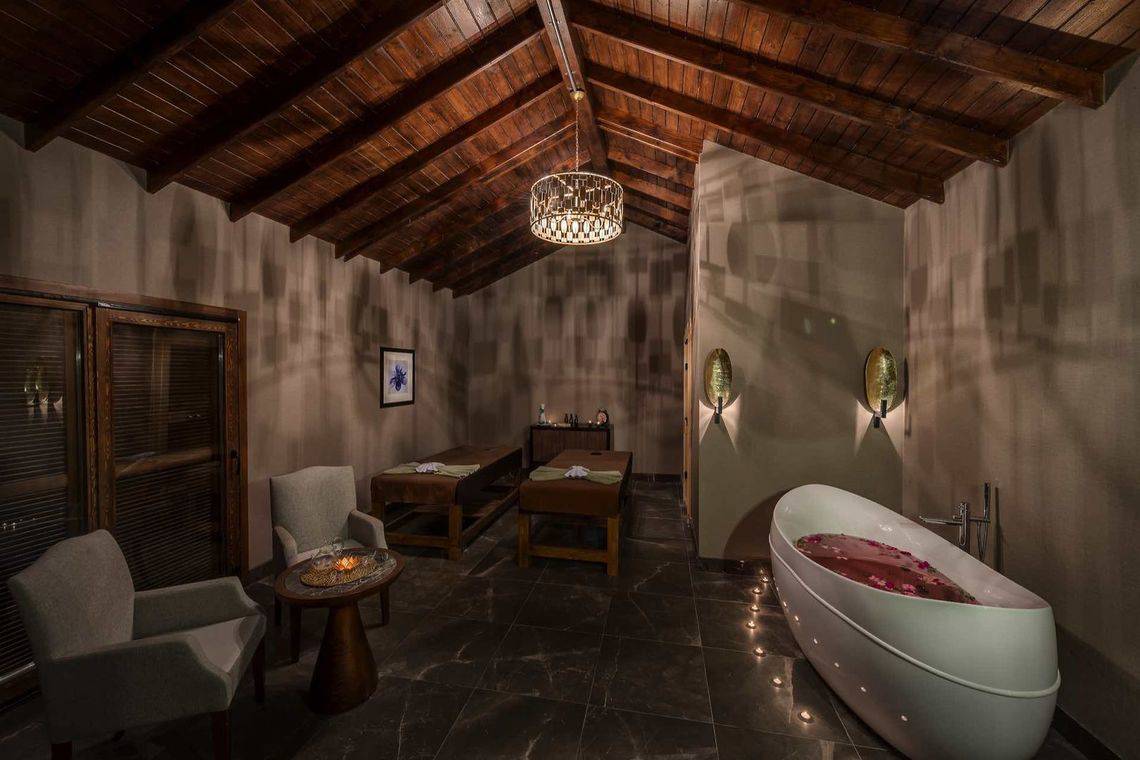 Spa-Behandlungsraum im Rixos Premium Tekirova Hotel mit Badewanne, Liegen und Deko.