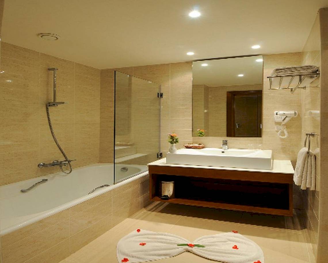 Ein Badezimmer mit Badewanne, Waschbecken und Spiegel im Vincci Helios Beach Hotel.