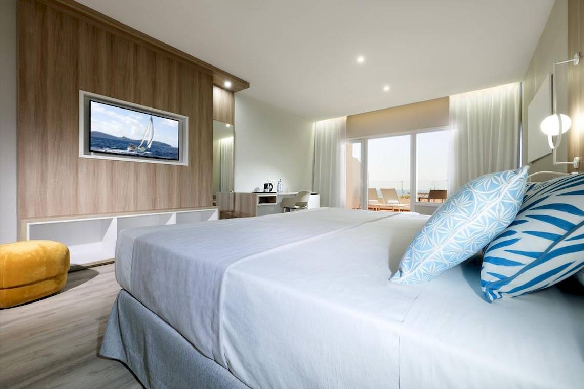 Schlafzimmer im Playabonita Hotel mit einem großen Bett und Meerblick