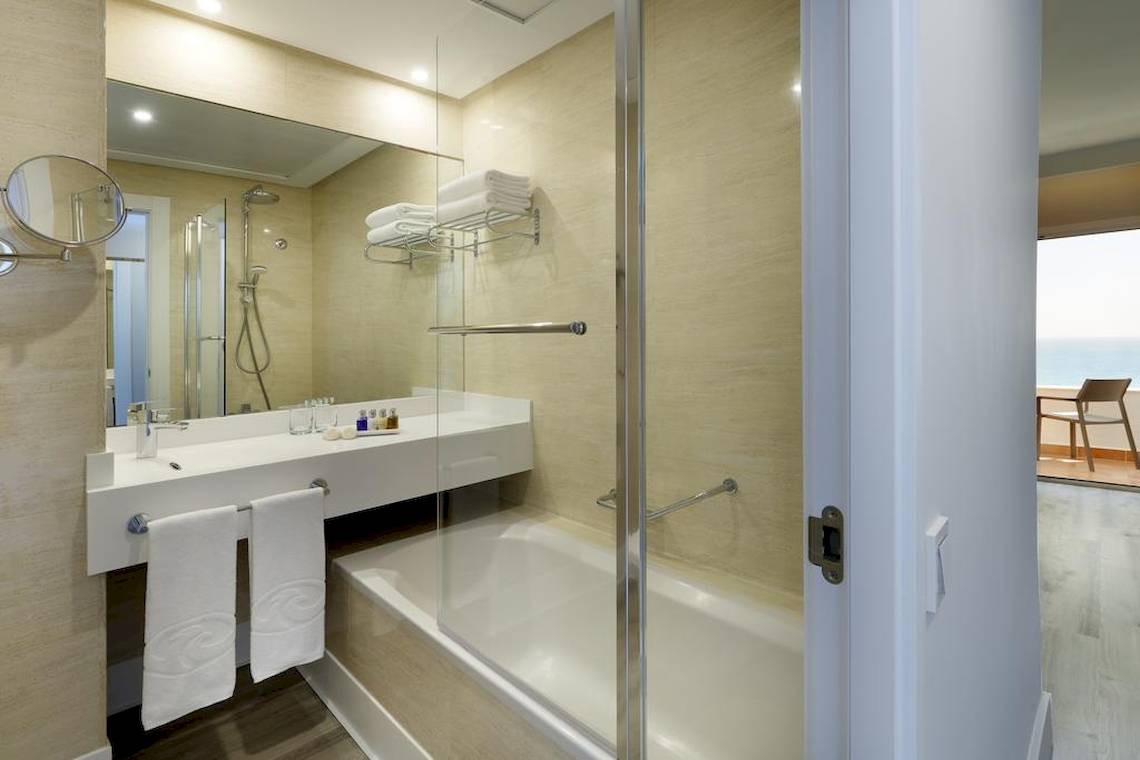 Badezimmer im Playabonita Hotel mit Dusche, Badewanne und Waschbecken.