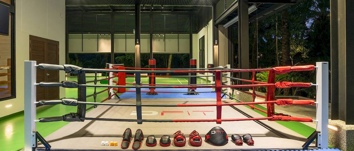 Boxring im Dusit Thani Krabi Beach Resort mit roten Ringpfosten und Trainingsausrüstung.