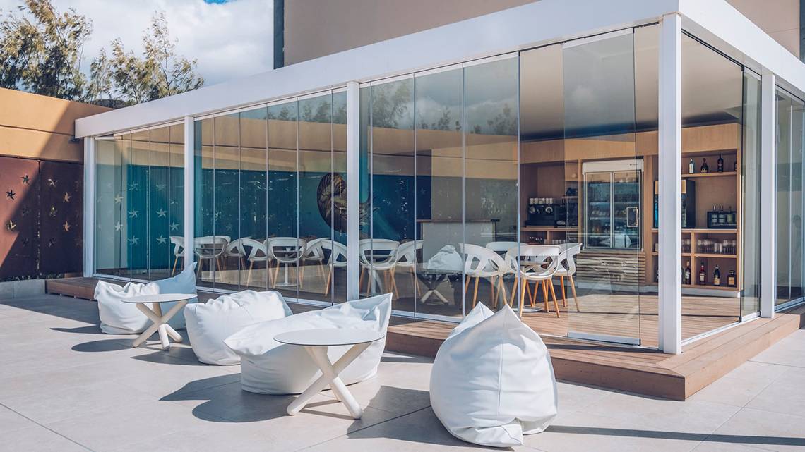 Außenbereich des Iberostar Selection Fuerteventura Palace mit großen Glaswänden und weißen Möbeln.
