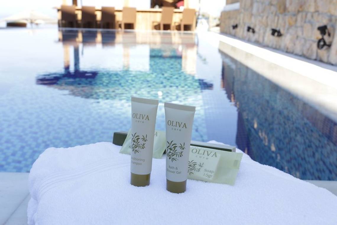 Pool am Almira Hotel mit Olivenpflegeprodukten auf einem Handtuch.