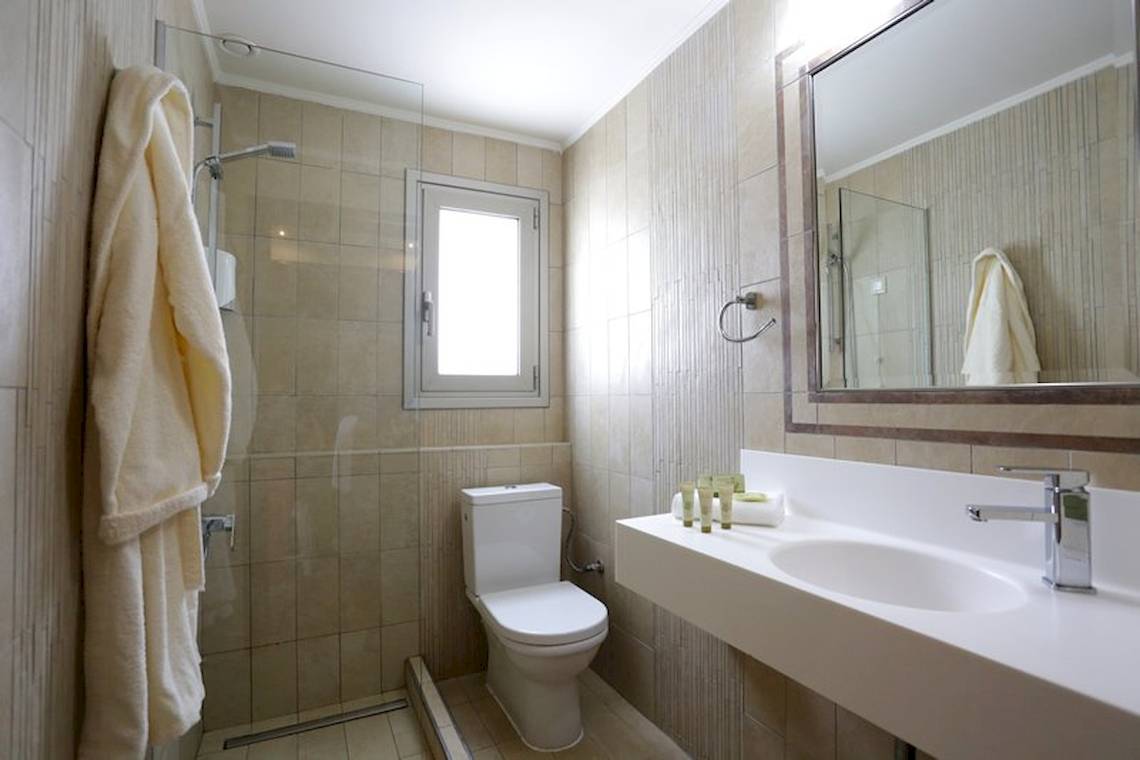 Badezimmer im Almira Hotel mit Toilette, Waschbecken und Spiegel
