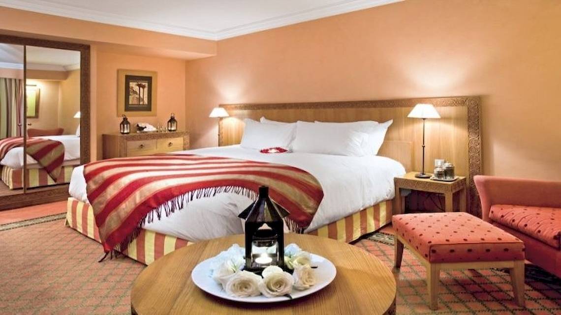 Hotelzimmer im Sofitel Marrakech Lounge & Spa mit Bett, Tisch, Rosen und Lampe