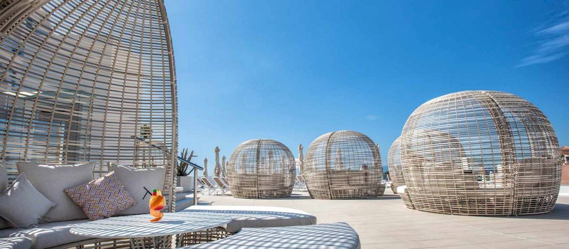 Loungebereich des Guayarmina Princess Hotels mit modernen Rattanmöbeln und Blick auf das Meer.