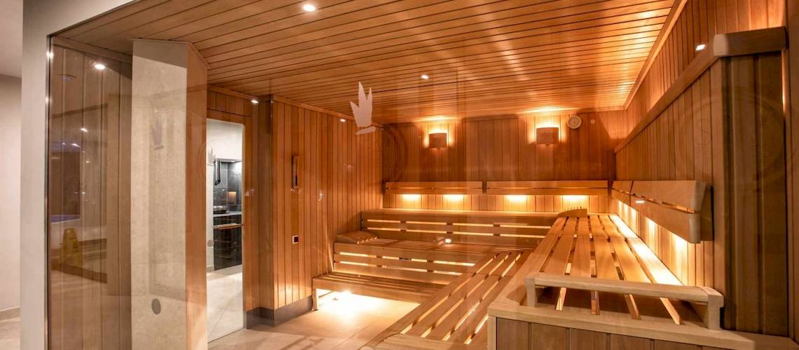 Innenansicht der Sauna im Guayarmina Princess Hotel mit Holzbänken und warmem Licht.