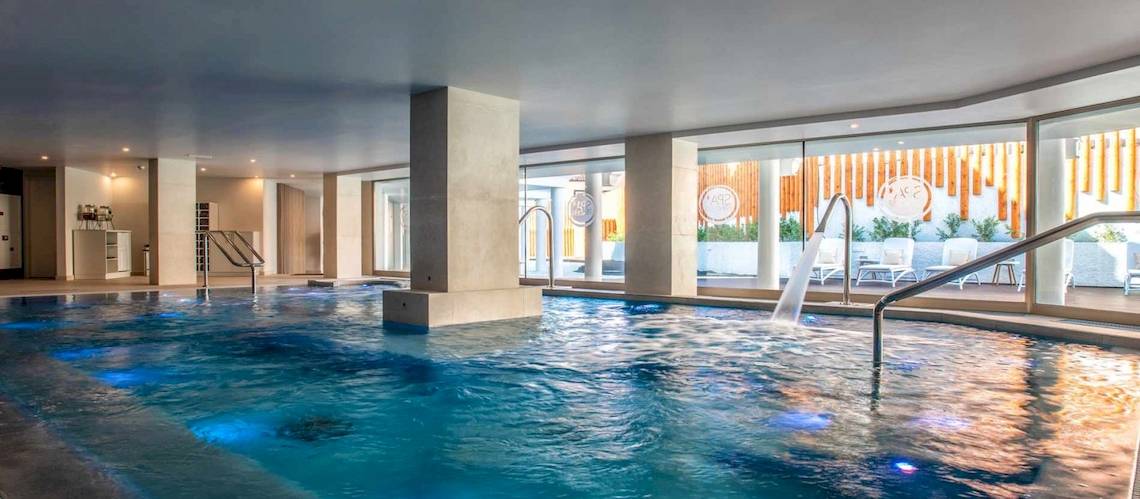 Innenpool des Guayarmina Princess Hotels mit blauem Wasser und blauen Lichtern.