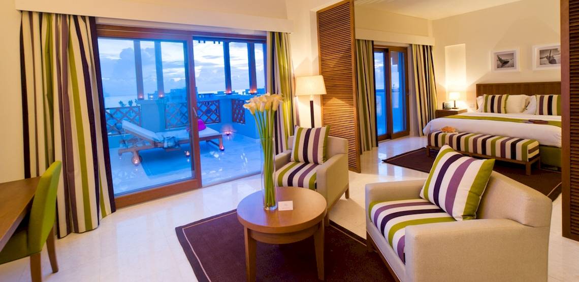 Innenansicht einer Suite im Sifawy Boutique Hotel mit Balkon, Schlafzimmer und Wohnzimmer.