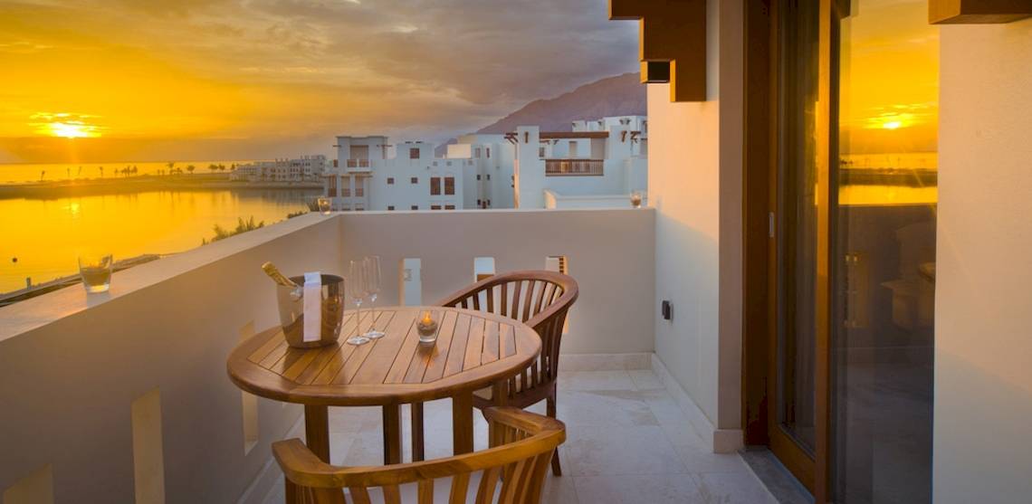 Balkon des Sifawy Boutique Hotels mit Blick auf den Sonnenuntergang über dem Meer.