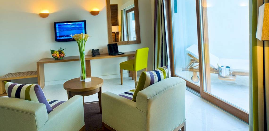 Sifawy Boutique Hotel Zimmer mit Fernseher, Schreibtisch und Gartenblick.