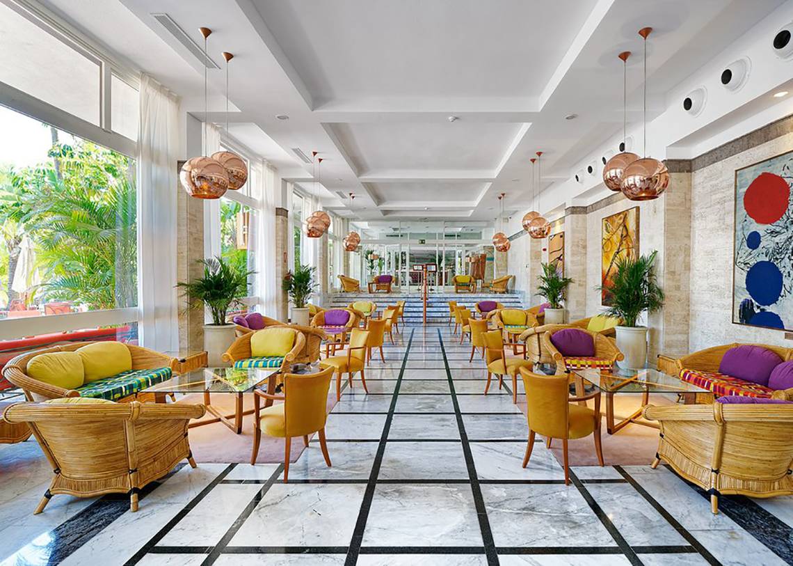 Innenansicht des Bull Costa Canaria & Spa Hotel-Lobbys mit farbenfrohen Möbeln und Pflanzen.