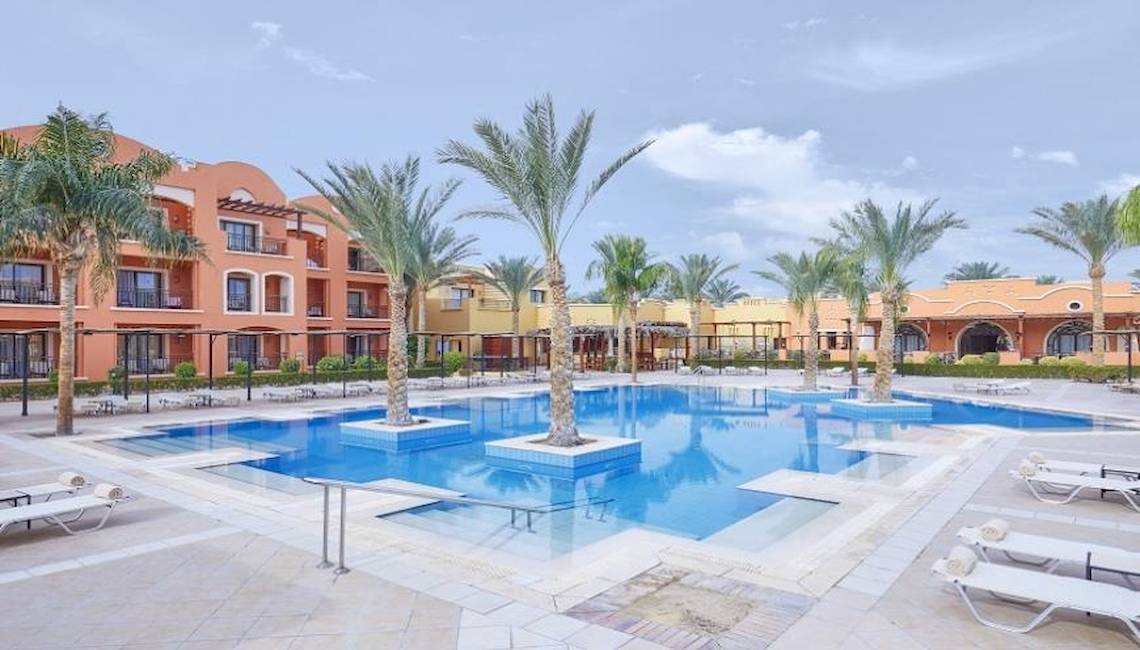 Außenbereich des JAZ Neo Dar El Madina Hotels mit Swimmingpool und Liegestühlen