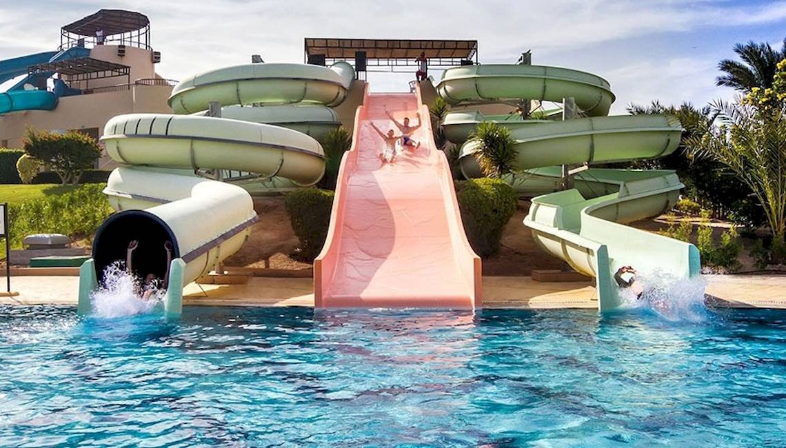 Wasserrutschen im Jaz Dar El Madina Hotel mit Personen, die die Rutschen hinuntergleiten.