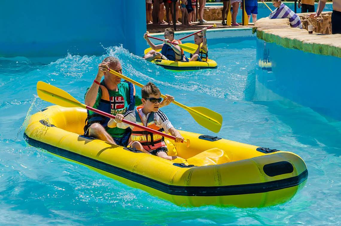 Familie paddelt mit Kajak im Schwimmbad des Titanic Palace Hotels