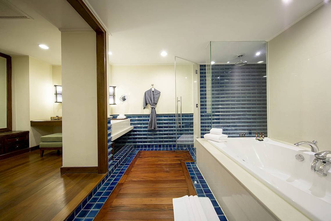 Das Badezimmer des Robinson Khao Lak Hotels mit blauen Fliesen, Badewanne und separater Dusche.