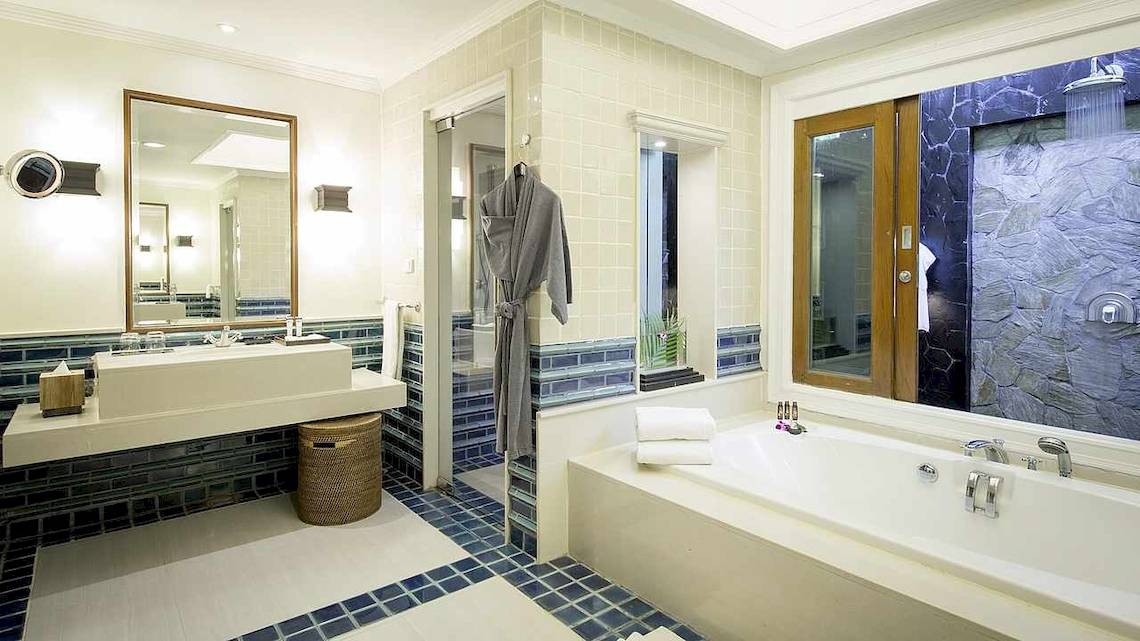 Badezimmer im Robinson Khao Lak Hotel mit Badewanne, Waschbecken und blauen Fliesen.