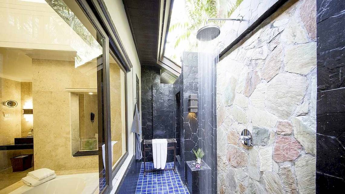 Badezimmer im Robinson Khao Lak Hotel mit einer Regendusche und einer Badewanne.
