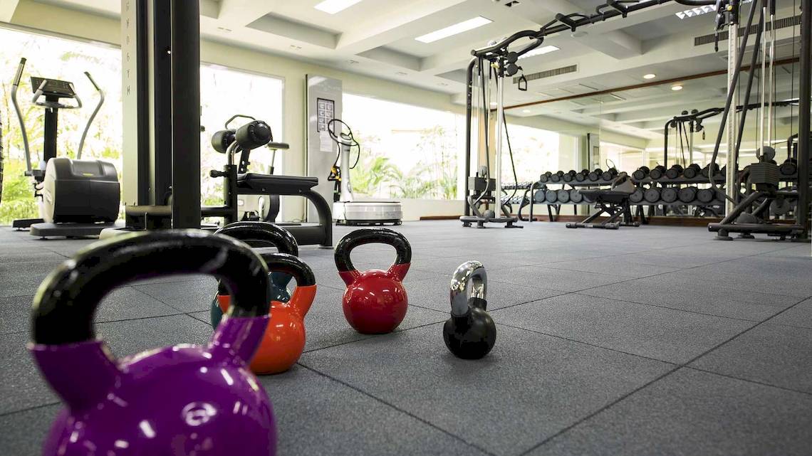 Fitnessstudio im Robinson Khao Lak Hotel mit Gewichten und Trainingsgeräten.