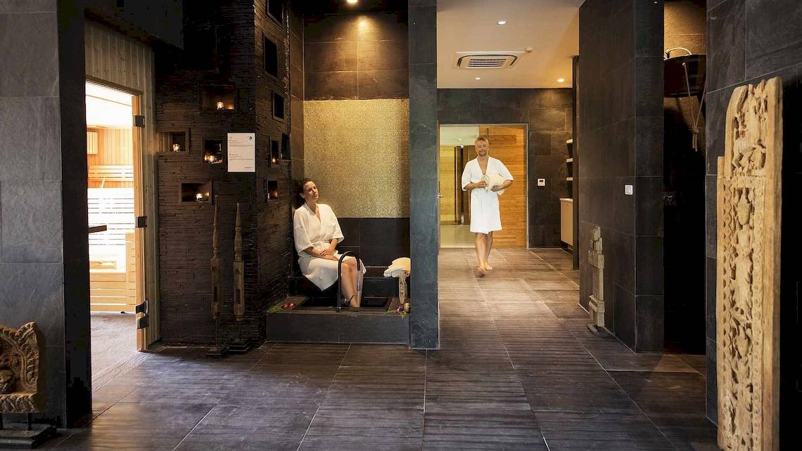 Innenansicht des Saunabereichs im Robinson Khao Lak Hotel mit zwei Personen in weißen Bademänteln.