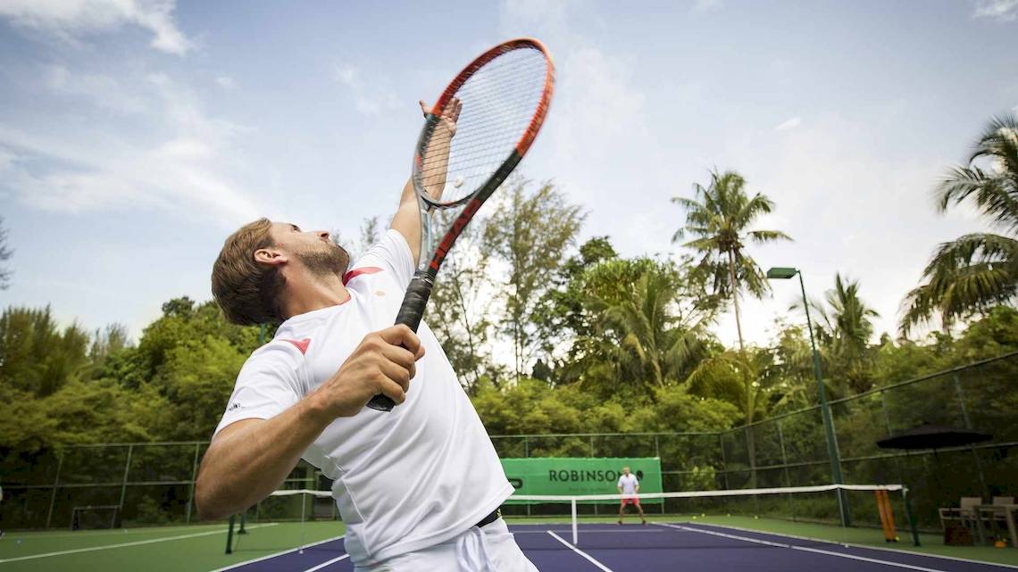 Tennisspieler im Robinson Khao Lak Hotel, der einen Ball schlägt.