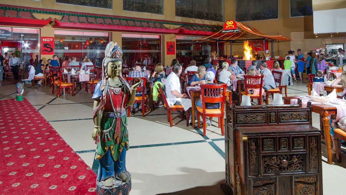 Innenbereich des Titanic Palace Restaurants mit Gästen an Tischen und einer Statue.