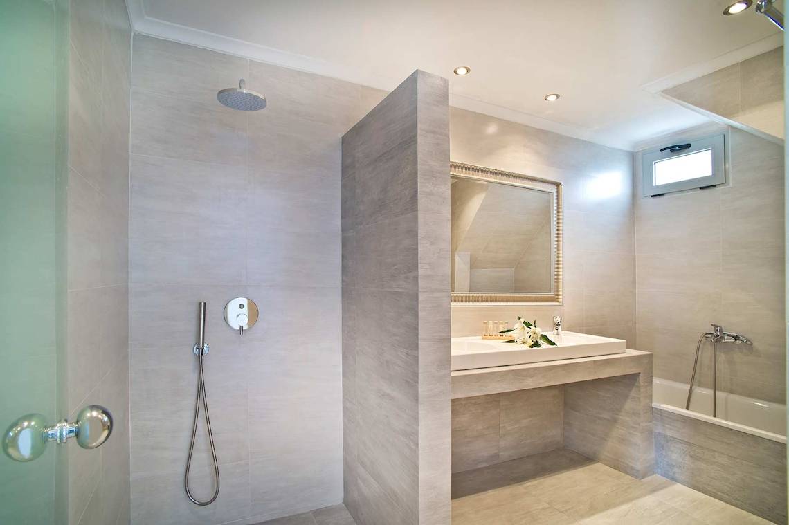 Badezimmer im Agali Houses Hotel mit ebenerdiger Dusche, Waschbecken und Badewanne