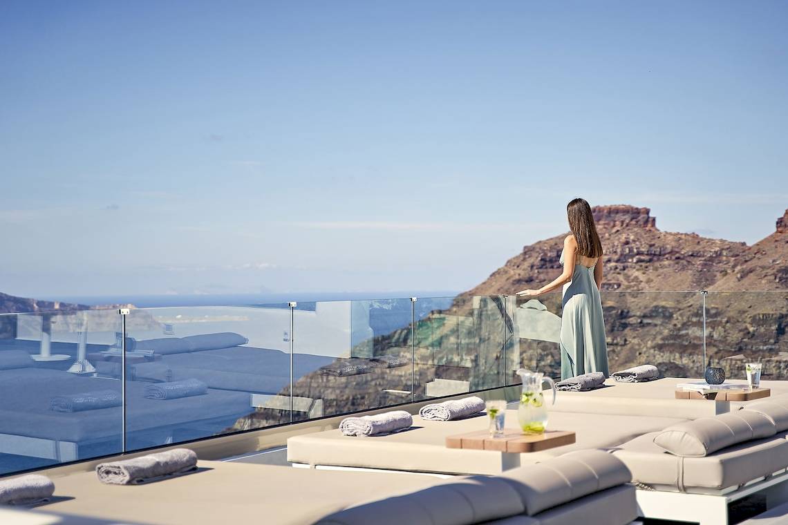 Aussicht von der Terrasse des Agali Houses Hotels mit Frau, die auf das Meer schaut.