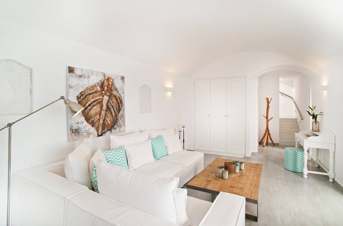 Modernes Wohnzimmer von Agali Houses mit weißen Möbeln, blauen Kissen und einem großen Gemälde an der Wand.