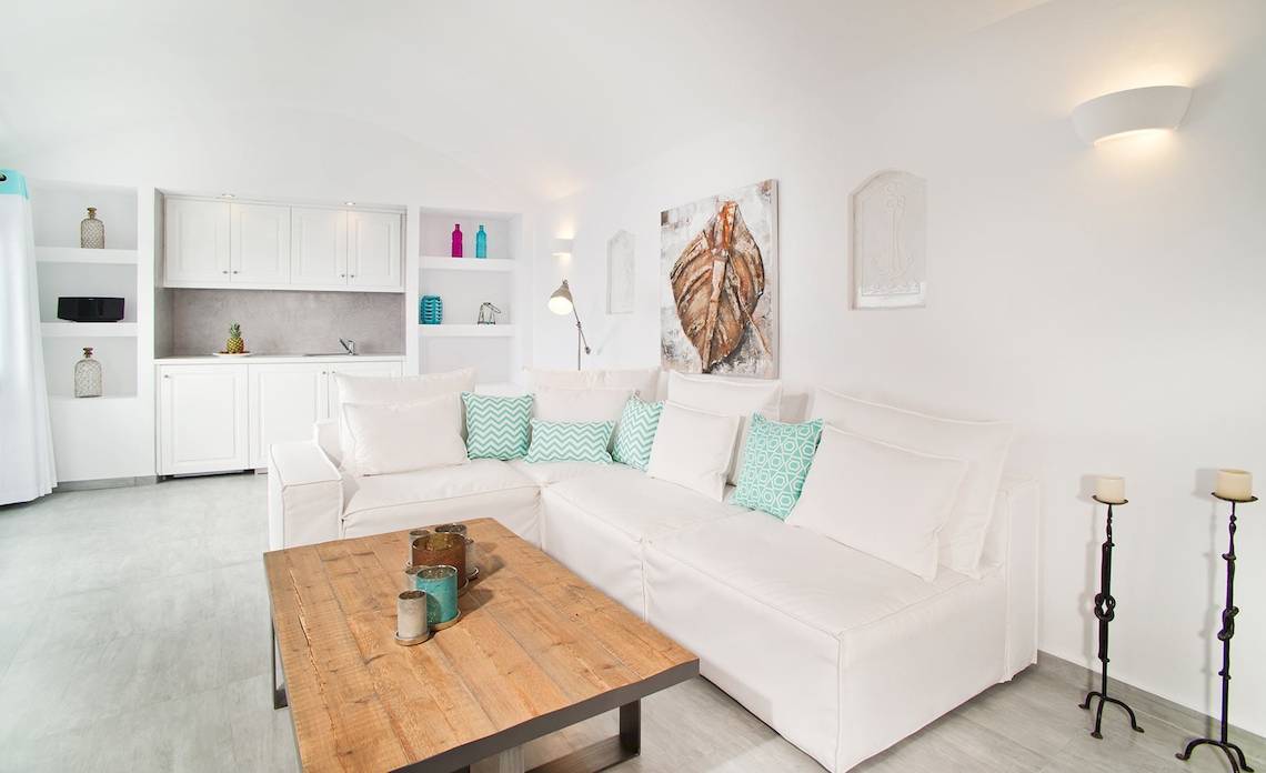 Weißes Wohnzimmer in den Agali Houses mit Couch, Holztisch und Dekor