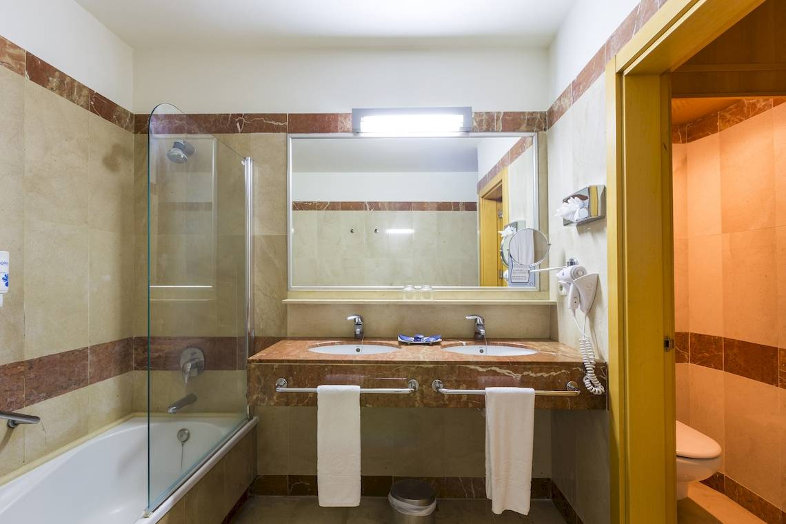 Ein Badezimmer mit zwei Waschbecken, einer Badewanne und einer Duschkabine.
