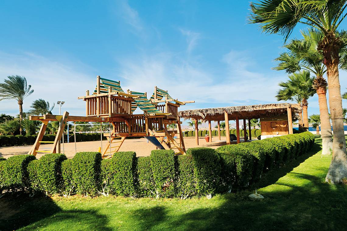 Freizeitbereich des Sharm Club Beach Resorts mit Spielplatz und Palmen