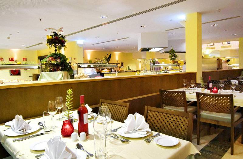Innenansicht des Restaurants im Playitas Hotel mit gedeckten Tischen und gelben Wänden.