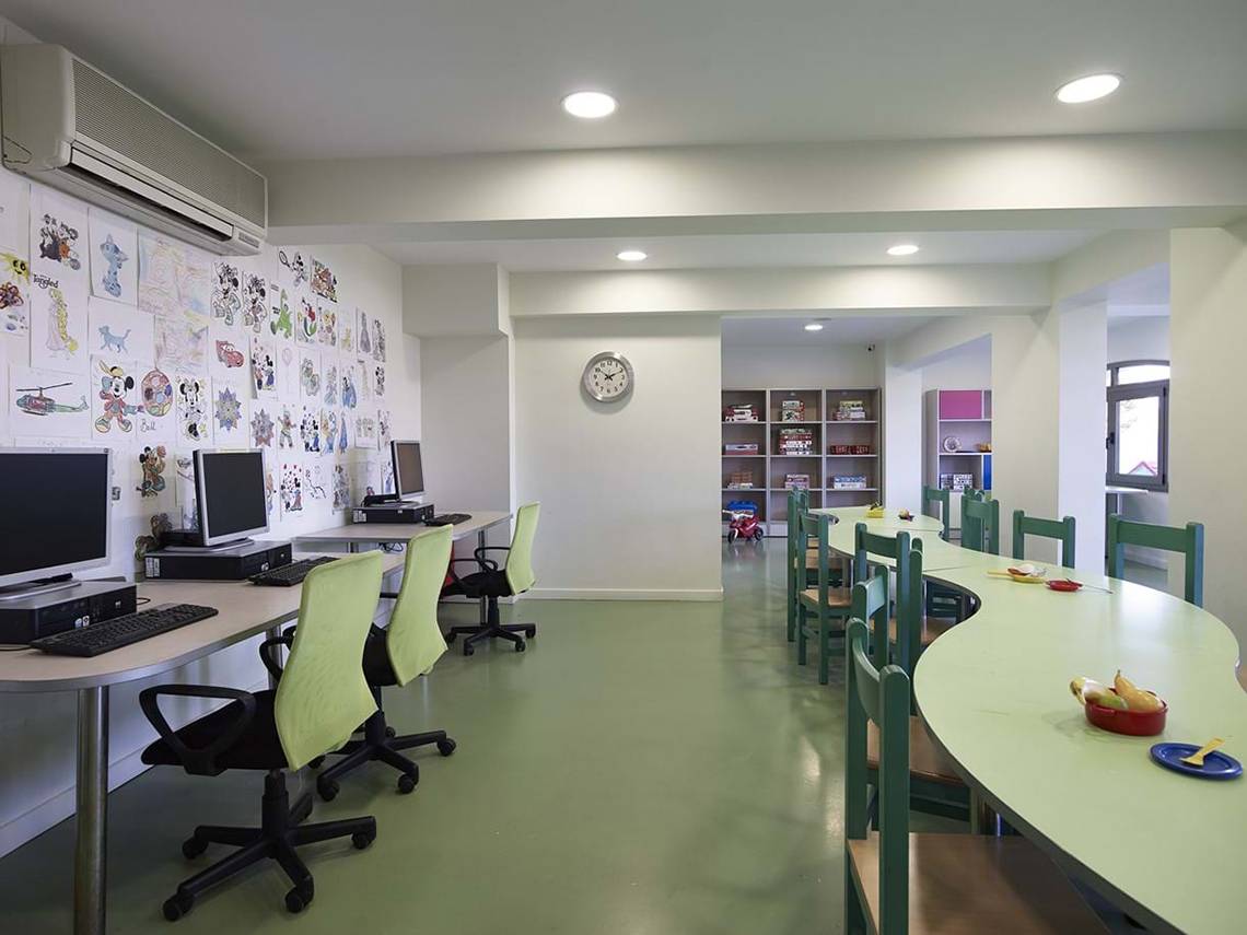 Innenansicht des Kinderzimmers im Creta Maris Resort mit Computern und grünen Tischen.