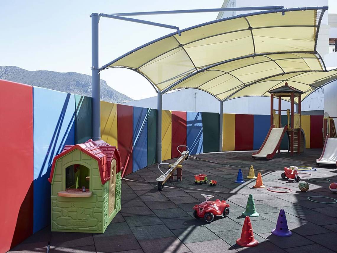 Kinderspielplatz im Creta Maris Resort mit Rutsche, Spielhaus und bunten Wänden.