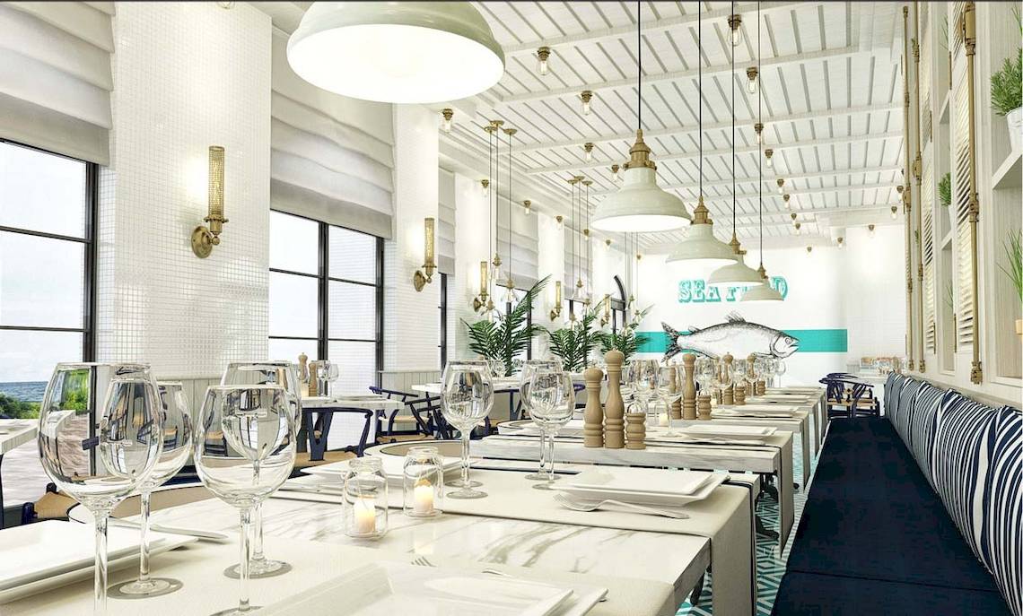 Innenansicht des Rixos Premium Saadiyat Island Restaurants mit Tisch, Gläsern und Meeresdekor.