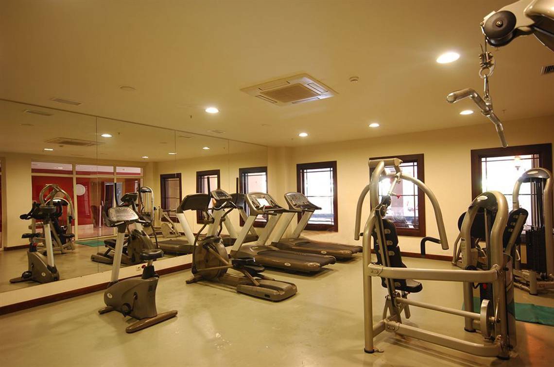 Fitnessstudio im Sealife Buket Resort & Spa mit mehreren Laufbändern und Spinnrädern.