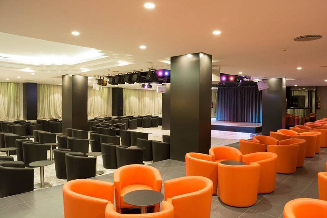 Loungebereich des Gran Canaria Princess Hotels mit orangen Stühlen und einer Bühne.