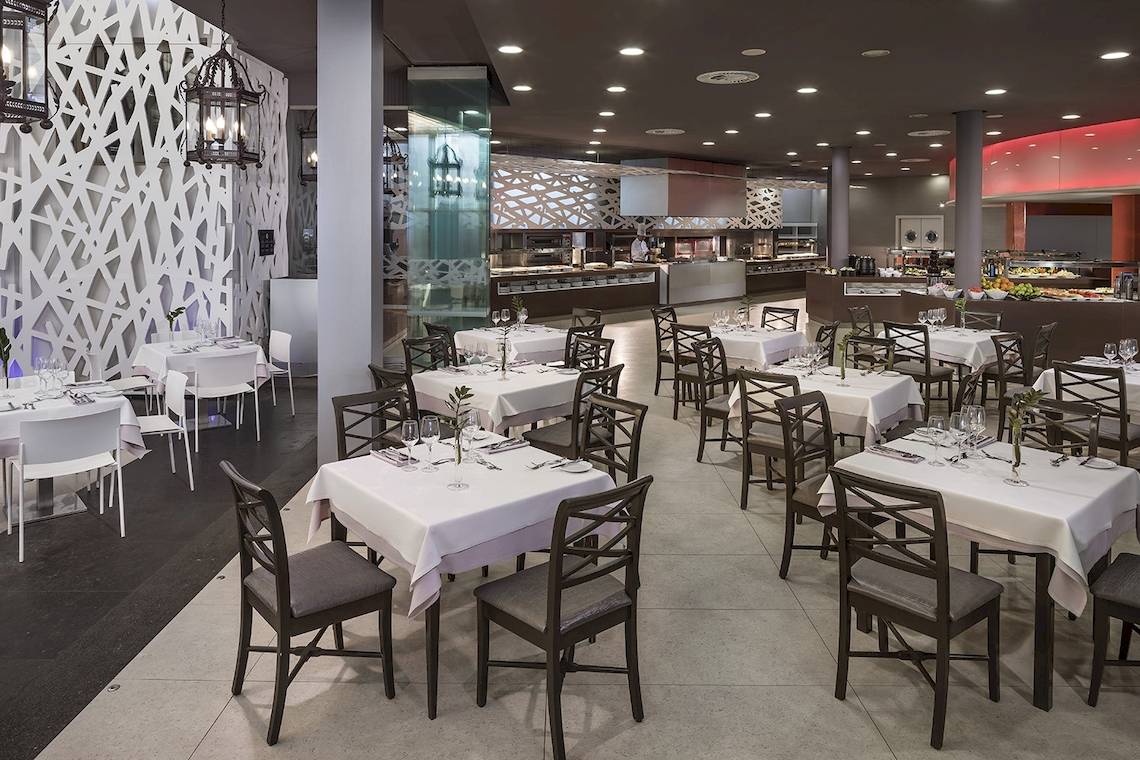 Innenansicht des Restaurants im HD Beach Resort mit gedeckten Tischen und Stühlen.