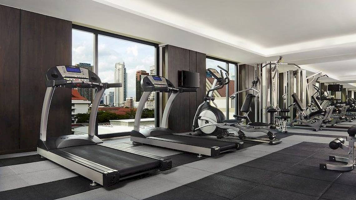 Fitnessbereich im Mövenpick Hotel Sukhumvit 15 Bangkok mit Laufbändern und anderen Geräten.
