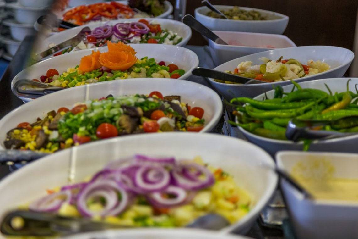Buffet im Callisto Holiday Village mit verschiedenen Salaten, Gemüse und Toppings.