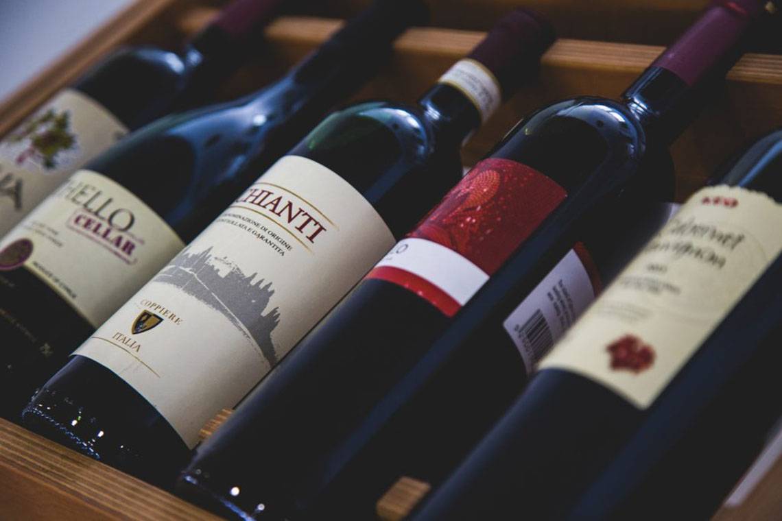 Mehrere Flaschen Rotwein in einem Holzregal