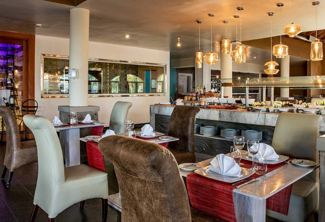 Innenansicht des Restaurants im Sunscape Coco Punta Cana Hotel mit gedeckten Tischen und Buffet.