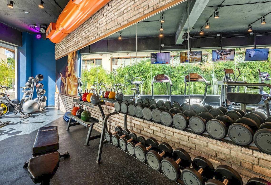 Innenansicht des Fitness-Centers des Sunscape Coco Punta Cana Hotels mit Hanteln und Trainingsgeräten.